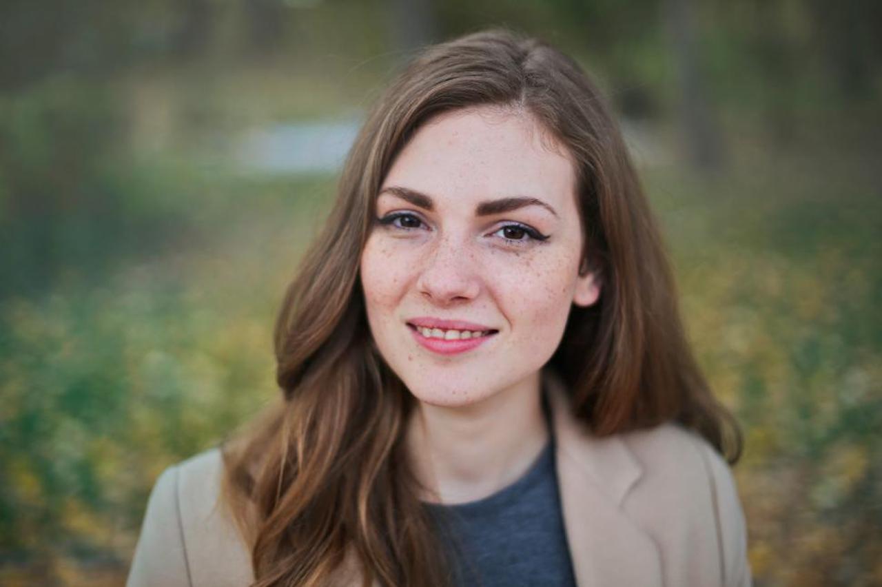 Portrait Of Brown Haired Young Woman In Brown Jacket